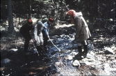 Ungdomsledare med barn leker i en bäck, 1970-tal