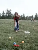 Flicka spelar boccia på gräset, 1970-tal