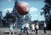 Ungdomar leker med boll på idrottsplan, 1970-tal