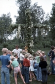 Ledare och ungdomar med rest midsommarstång, 1970-tal