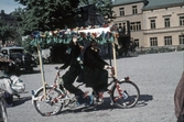 Clowner på tandemcykel med dubbelt styre i Barnens dag-tåget, 1950-tal