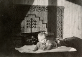 Babyn Eva Pettersson (gift Kempe) ligger på mage på en filt år 1944.