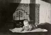 Babyn Eva Pettersson (gift Kempe) ligger på mage på en filt år 1944.