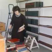Kvinna sorterar böcker på Regionsjukhusets bibliotek, 1965
