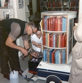 Elektriker inspekterar bokvagnens batterier på Regionsjukhuset, 1968-07-17