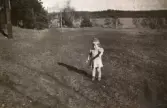 Lilla Eva Pettersson (gift Kempe) står på gräsmattan vid Stretereds personalbostad i Tulebo 1946. Mormor och morfar bodde där. I bakgrunden ses Tulebosjön.