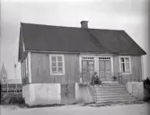 Parstuga med stående träpanel med en man på trappan.