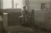 Eva Pettersson (född 1944, gift Kempe) sitter i en Emma-fåtölj i föräldrarnas sovrum, Torrekulla 1947.