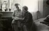 Rosa Pettersson hjälper dotter Eva (gift Kempe) att läsa läxan, Gamlehagsvägen 17 i Torrekulla, år 1952.