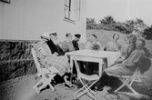 Familj samlad runt trädgårdsbordet, 1940-tal