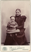 Mor med sin dotter i knät hos fotografen, 1898 ca
