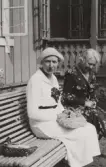 Två kvinnor på en soffa utanför Pettersbergs gård, 1930-tal