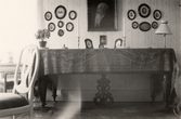 Familjeporträtt ovanför bord med stor duk på Pettersbergs gård, 1930-tal
