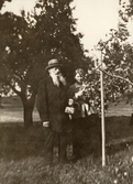 Far och dotter plockar äpplen på Pettersbergs gård, 1919