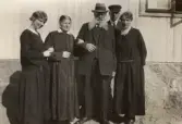 Familjen Larsson håller armkrok med varandra på Pettersbergs gård, 1920
