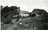 Gammal gård nära Lerkil i Vallda. Bostadshus och ladugård med utedass. Farstun till bostadshuset har välvt tak.