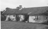Bostadhuset på gården Berget mellan Gottskär och Prästäng. Fönstren är försedda med fönsterluckor och taket är täckt med enkupiga tegelpannor.