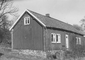 Timrad stuga sedd från gaveln, Nordgården norr om Budskär, Släp. Knutlådorna täcker de utskjutande ändarna av väggtimret. (Se även G8457)