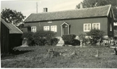 Gården Kullen vid landsvägen mellan Vrå och Lunden i Vallda. Bostadshuset står på en hög stengrund med en trappa utan räcken till dörren. Gårdsytan är belagd med kullersten, där gräset fått fäste.