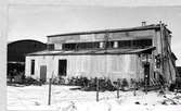 Varbergs hamn. Fabrik för rivning av fodercellulosa. Längs byggnaden står arbetarnas cyklar parkerade. Tillhör samlingen med fotokopior från Hallands Nyheter som är från 1930- 1940-talen.