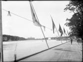 Stockholmsutställningen 1930
Strandpromenad med flaggor. Vy över vatten med Nordiska museet i fonden.