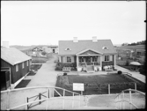 Stockholmsutställningen 1930
Demonstrationsgården (?). Bostadshus i förgrunden med träffpunkt för utandssvenskar, Nora trädgårdsstads specialutställning.