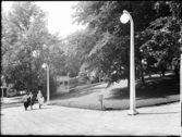 Stockholmsutställningen 1930
Små paviljonger i sluttning med gatlyktor i förgrunden.