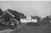 Arbetskarlar kommer gående med hästar vid Ysby gård i Vallda.