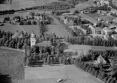 Flygfoto över Orsa. Orsa kyrka, år 1953. Läs mer om Orsa kyrka i boken:Dalarnas kyrkor i ord och bild.