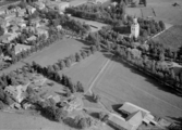 Flygfoto över Orsa. Orsa kyrka, år 1953. Läs mer om Orsa kyrka i boken: Dalarnas kyrkor i ord och bild.