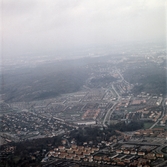 Flygfoto över de centrala delarna av Mölndal, okänt årtal. Broslätt och Mölndalsbro mot Solängen, Jungfruplatsen, Bifrost och Bosgården. I bakgrunden ses även Toltorp.