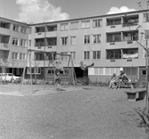 Mor och barn vid gungorna på lekplats i Markbacken , 1960-tal