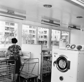 Kvinna använder tvätthon i tvättstuga i Markbacken, 1960-tal