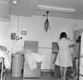 Kvinna vid centrifug i tvättstuga i Markbacken, 1960-tal