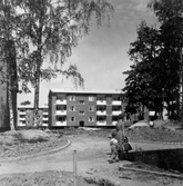 Mor och barn går genom Norrby, 1960-tal