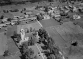 Flygfoto över Skattungbyn. Skattunge kyrka år 1953. Läs mer om Skattunge kyrka i boken: Dalarnas kyrkor i ord och bild.