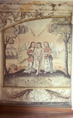 Detaljbild av väggmålning. Landskapsbild med stad i bakgrunden. I förgrunden två änglar, en på vardera sida om Jesus, med bundna händer.
Latinsk text med bland annat 