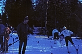 Skidåkare och funktionär vid distriktsmästerskapen i längdskidåkning i Ånnaboda, 1970-tal