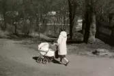 Ninnie Tobiasson (född Johansson 1937) promenerar nedför Krokslättsskolans skolbacke med dottern Ilse (född 1960, gift Glimberg) liggandes i barnvagnen. De har varit på besök hos mormor och morfar som bodde i en lägenhet snett mittemot skolans framsida (byggnaden är riven). Familjen har sett ett TV-program då prinsessan Margret (1930 - 2002), grevinna av Snowdon, år 1960 gifte sig med Anthony Armstrong-Jones (1930 - 2017). I fonden mellan träden skymtar Krokslätt och dess fabriker till höger.