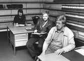 Tre män i gemensamt arbetsrum, 1970-tal
