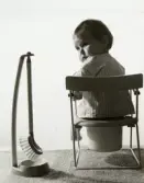 13 månader gamla Ilse Tobiasson (gift Glimberg) sitter på en potta, Bågskyttegatan 3g april 1961. Hon är fotograferad av en hobbyfotograf (namn saknas) som bodde i samma trappuppgång som familjen Tobiasson.