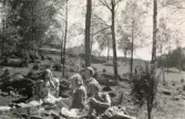 Rosa Pettersson (född Krantz), dottern Eva (gift Kempe) och hennes lekkamrater Lena Englund och Monika Axelsson har picknick i det gröna efter att flickorna har kastat varpa, Insered i Hällingsjö 1957. Relaterat motiv: 2023_0154.