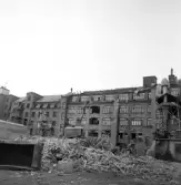 Grävmaskinen står på rivningsmassa för att riva mer på Fredsgatan 4, 1970-tal