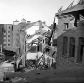 Från grannfastigheten ser man grävskopans rivningslusta på Fredsgatan 4, 1970-tal