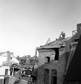 Man bryter bort taket på Fredsgatan 4 under rivning, 1970-tal