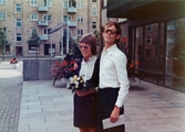 Nu var det klart! Brudparet Karin (född Pettersson) och Esbjörn Hansson står utanför Mölndals stadshus efter giftemålet 1973-09-29. I bakgrunden ses lägenheter på Tempelgatan.