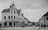 Storgatan, Ludvika. Skyltar med text: Hendebergs; Telegraf telefon; Ritz hotell; Bageri; Färg; Trikåaffär.