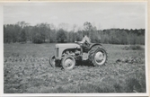 En man kör en traktor på åkern, 