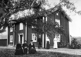 Grupp framför hus i Frösvi, 1910-tal