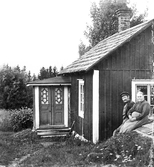 Snickaren med hustru framför sitt hus i Knista, 1910-tal